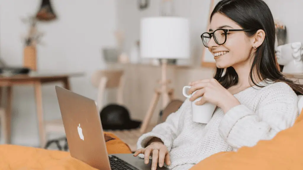 Woman having a coffee while using her laptop