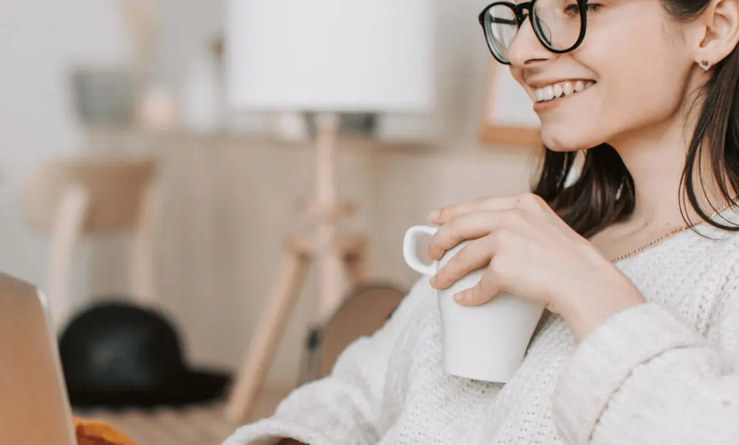 Woman having a coffee while using her laptop