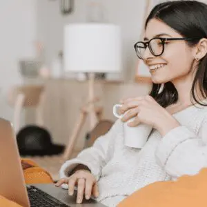 Nannytax Blog Top 5 Resources for Nannies (1080 x 1080 px) Woman having a coffee while using her laptop