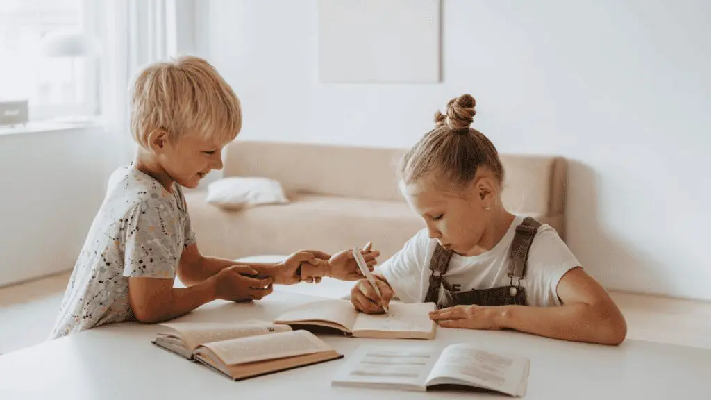 Two children sitting at a table doing homework